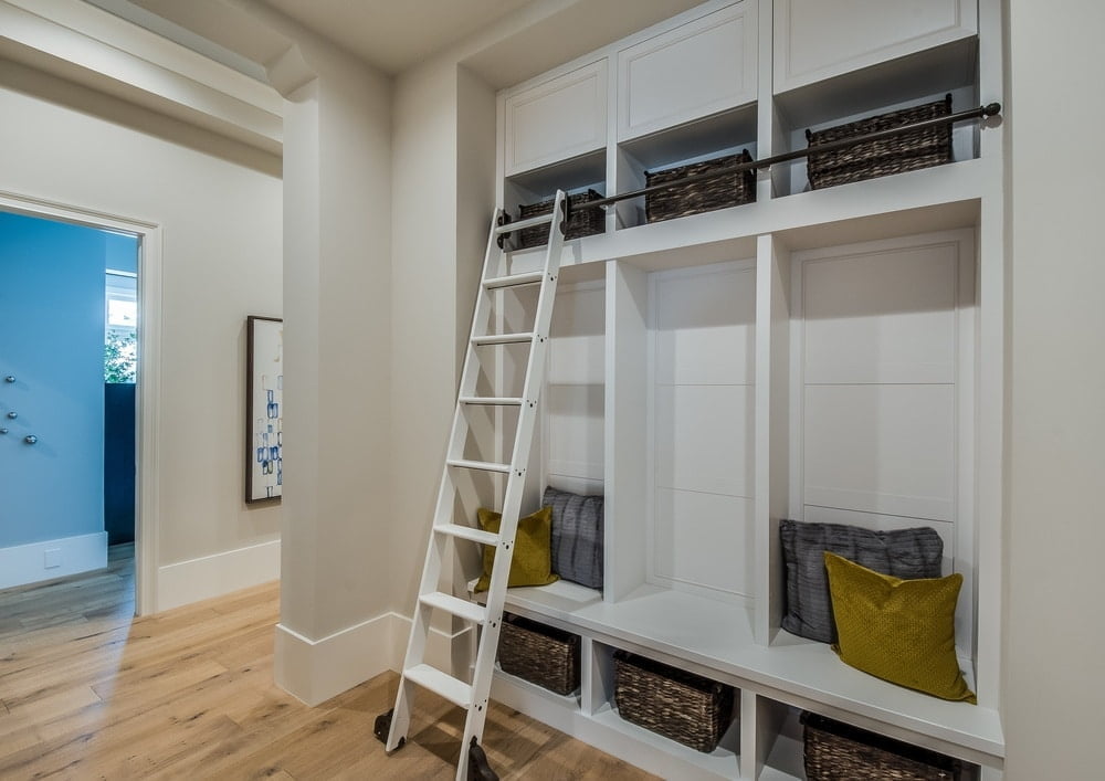 White built in mudroom with shelves and a ladder