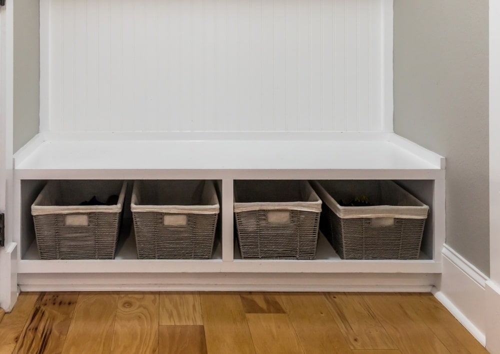 A white mudroom bench with storage underneath