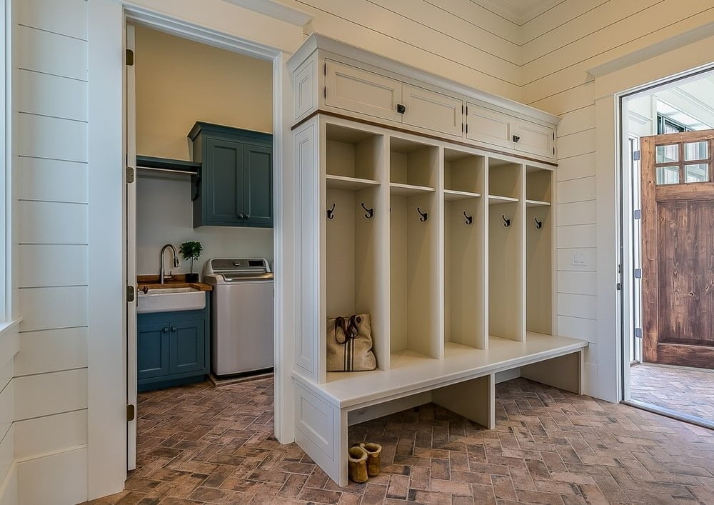 Entryway that has white mudroom cabinet with bench