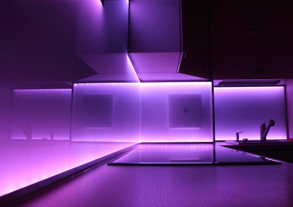 A dark pantry counter illuminated with purple leds