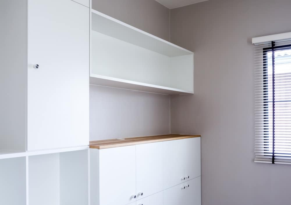 Pantry with empty white shelves and cabinets