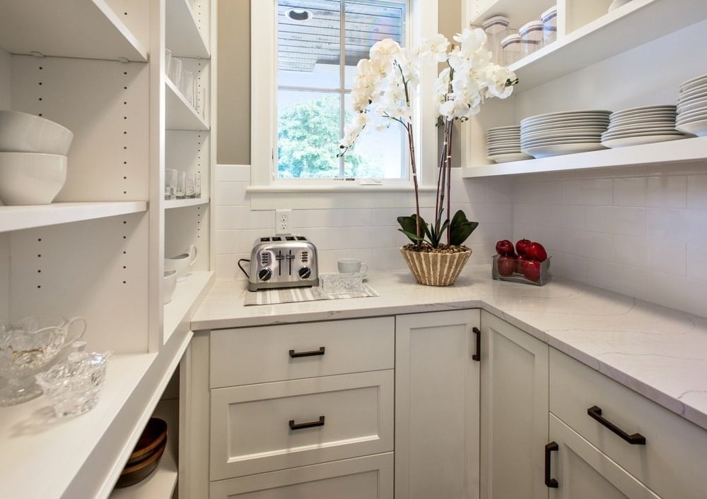 White narrow pantry with counter drawers and open shelves