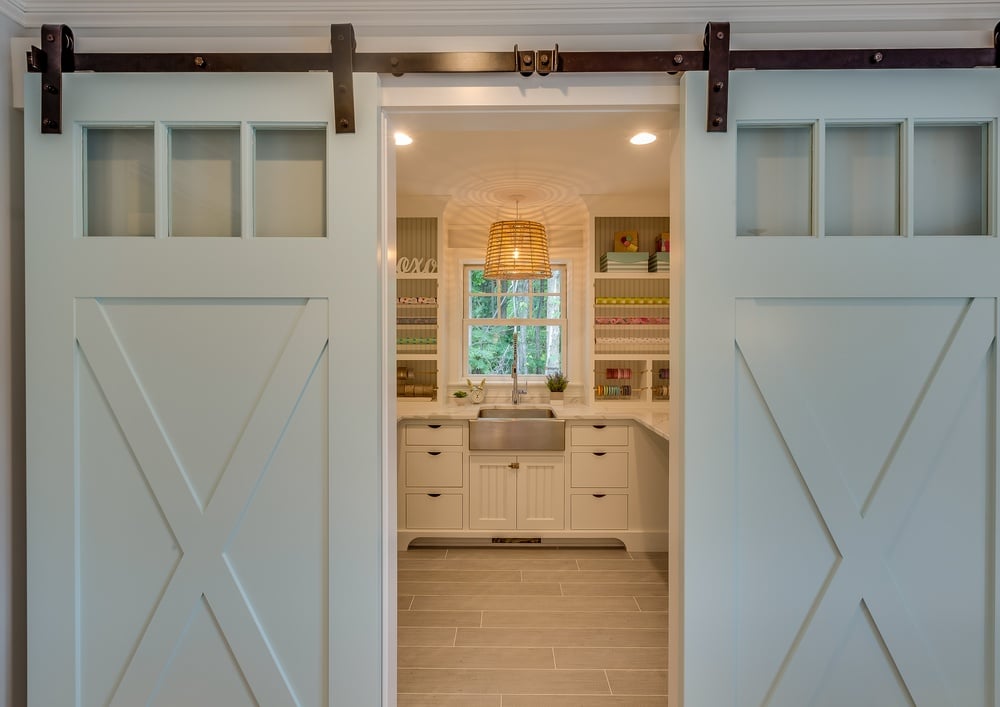 Pantry with sliding barn doors that are slightly open