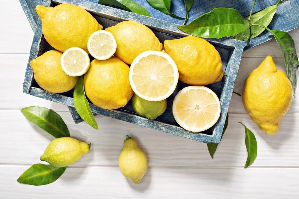 Lots of lemons standing on a table in a box