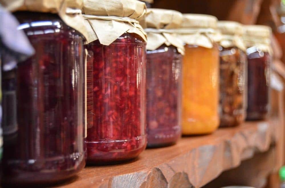 Preserved foods in jars on a wooden shelf