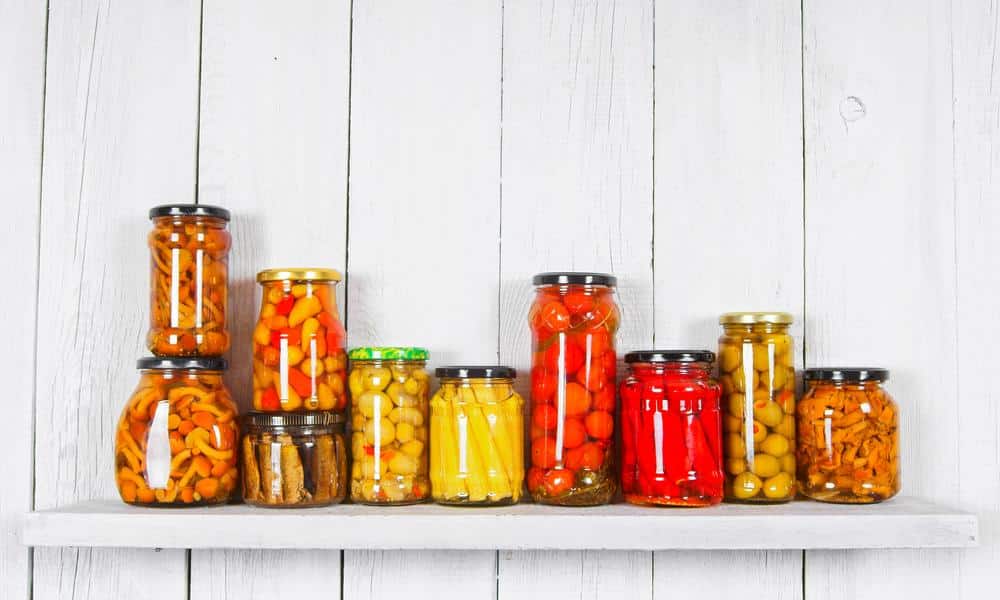 Preserved food jars on a white wall shelf