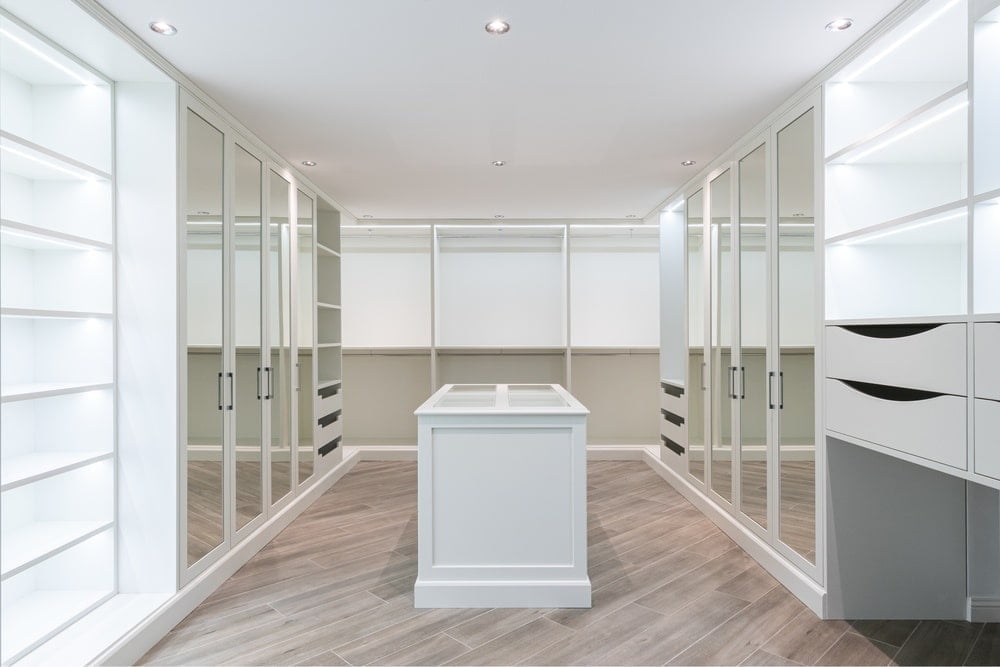 Empty, large, light colored walk-in closet with island