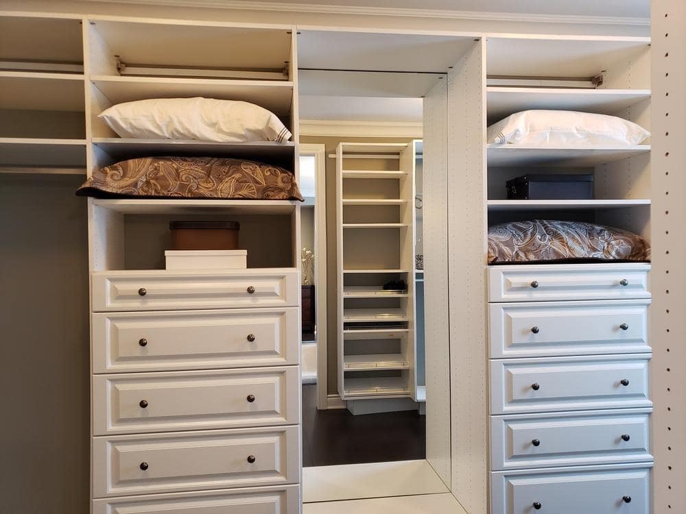 A walk in closet that has shelving units and drawers