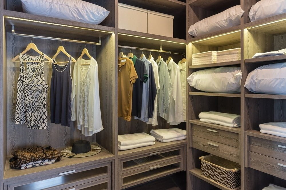 A walk in closet that has shelves, drawers and hanging racks