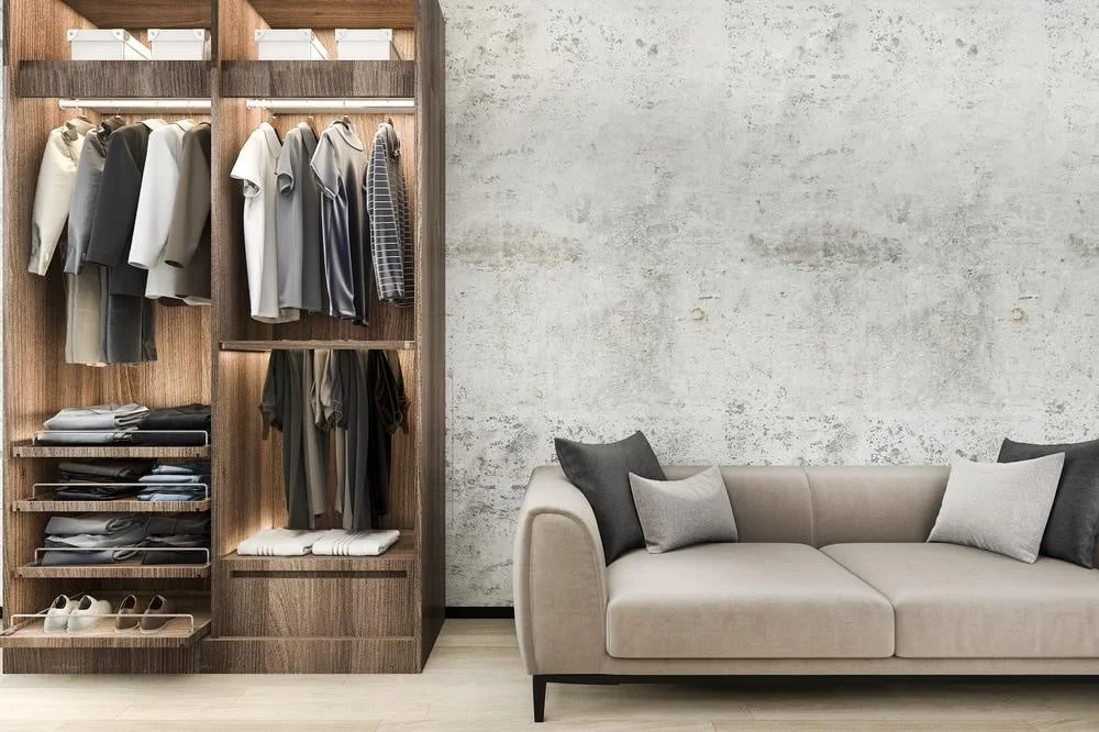 A wooden led lighted wardrobe with open doors next to a grey sofa