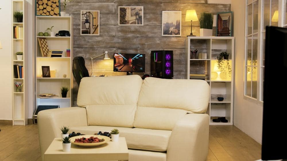 A gaming room design that has pc setup and a large white sofa