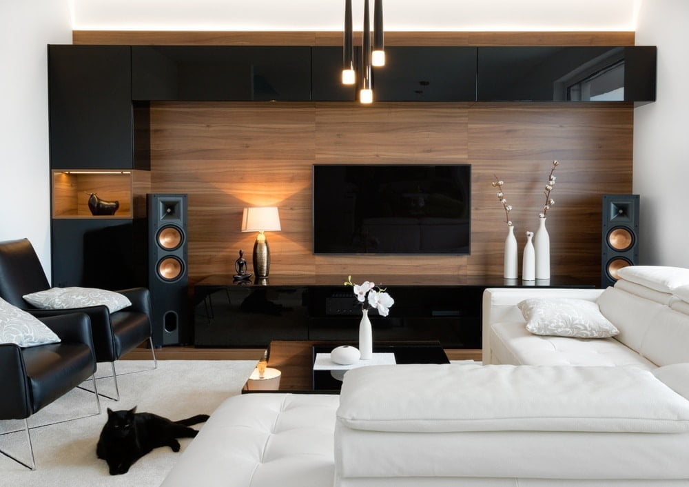 Large black and white tv unit in a living room that has white sofas