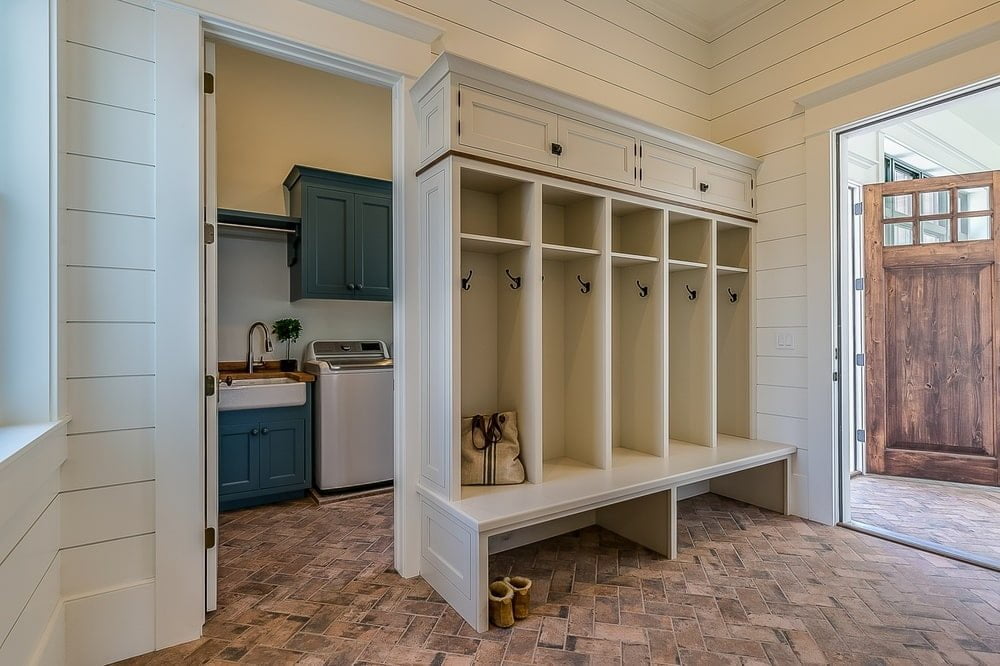 White mudroom with hanging pieces and large bench