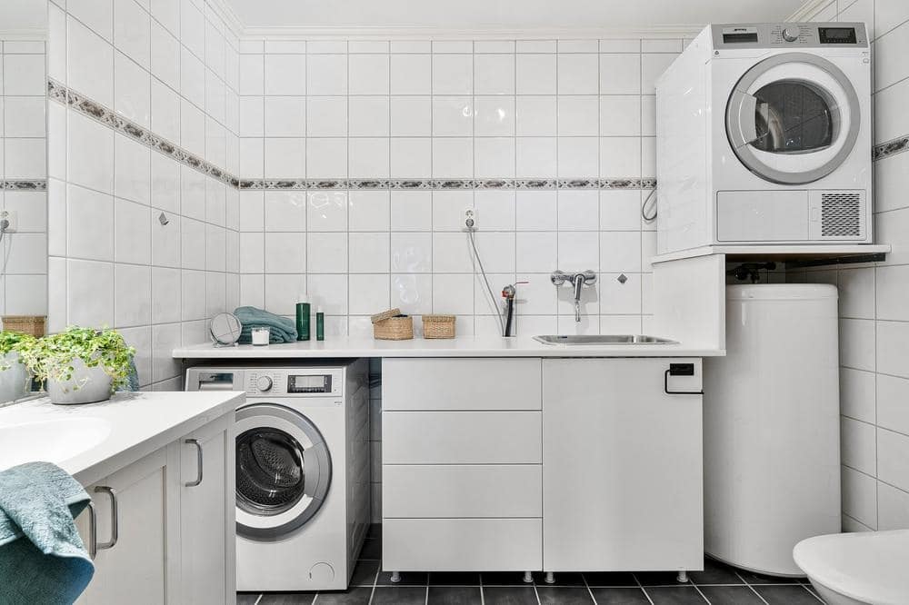 White laundry room with a counter and drawers and cabinets