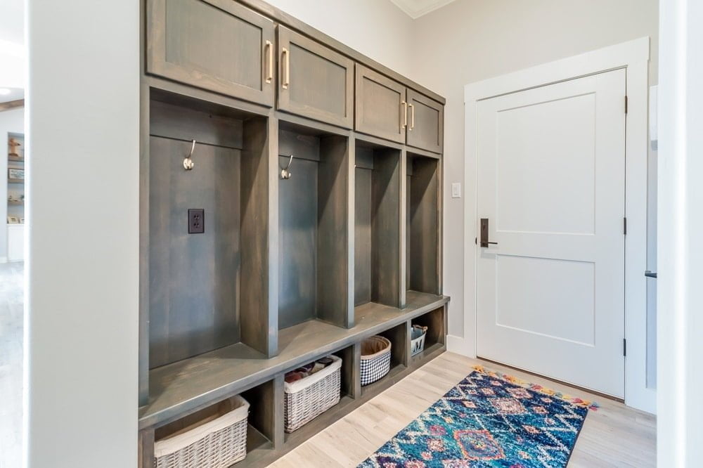 A mudroom with wall hooks next to a white door