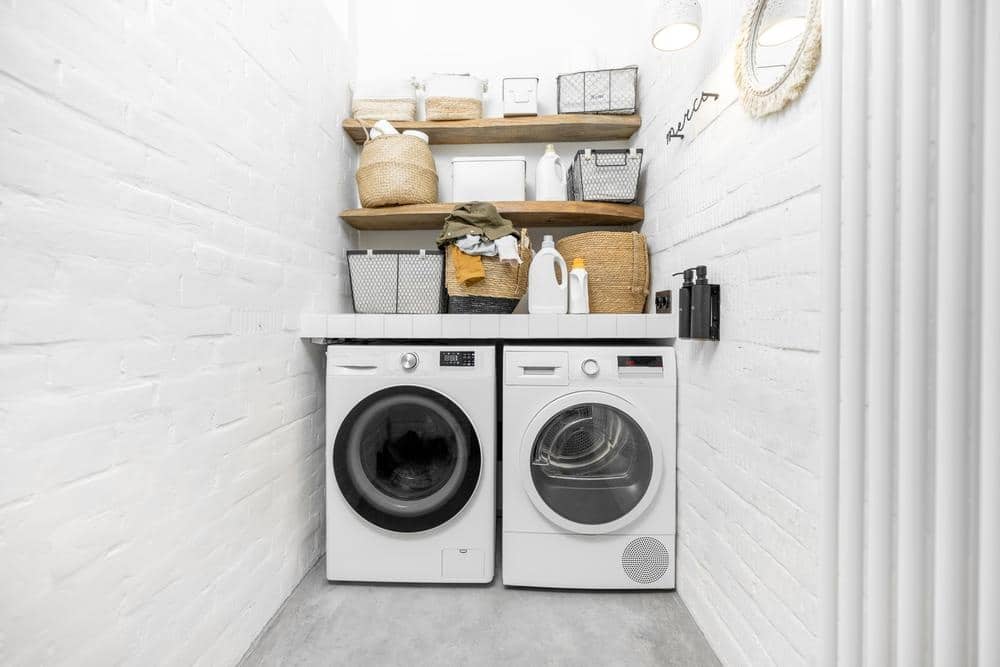Narrow laundry room with washer dryer and shelves
