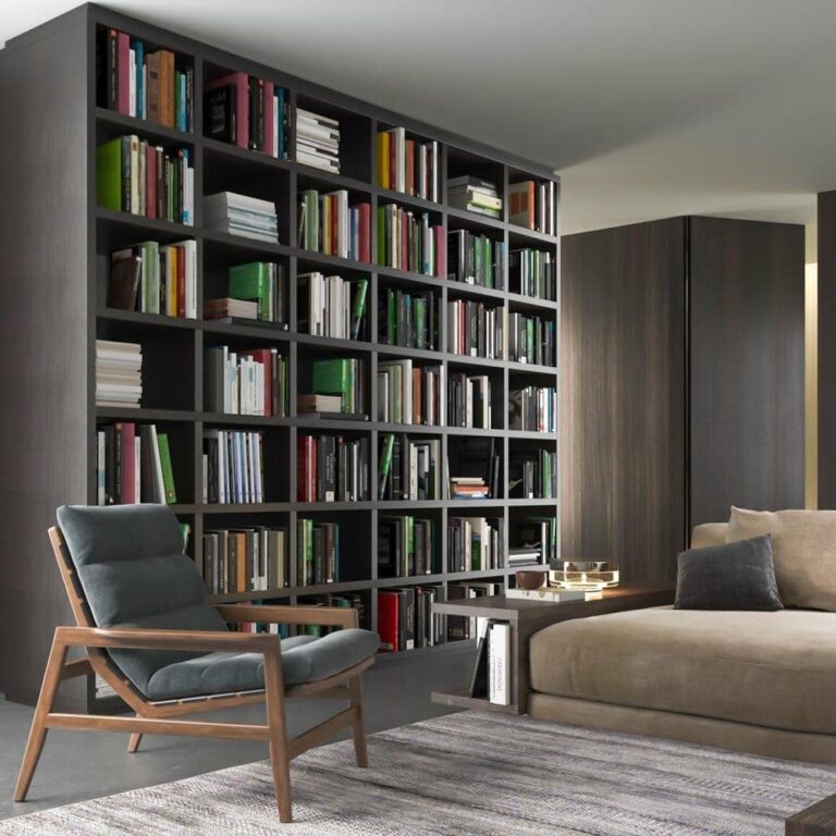 Living room with dark grey bookcase filled with books covering a wall