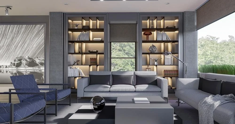 Large windowed living room with grey couches and two lighted bookcases