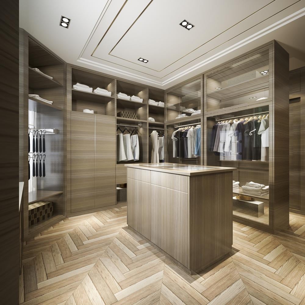 Wooden floor walk in closet with wooden cabinets and island