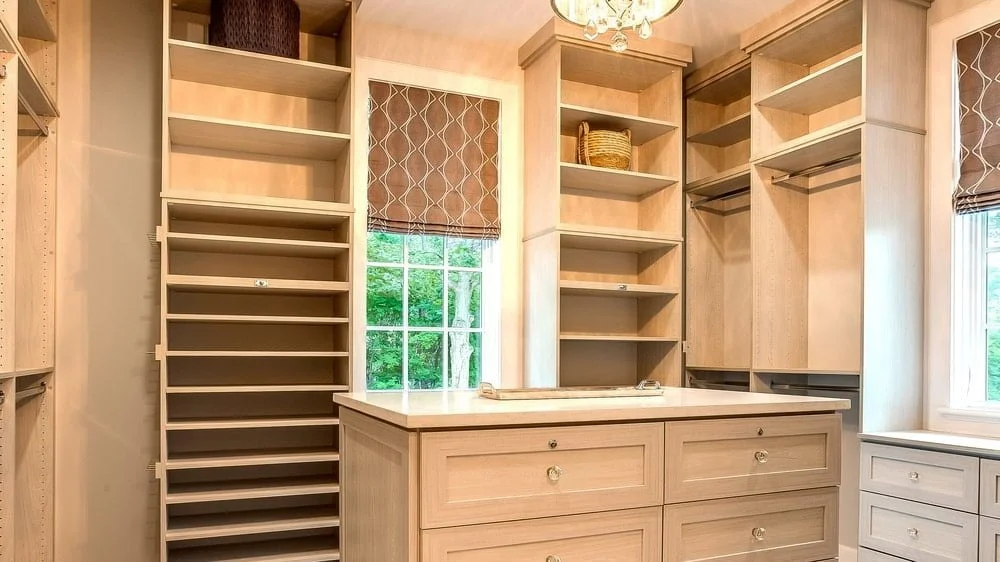 Light wooden walk-in closet with open shelves and organizers