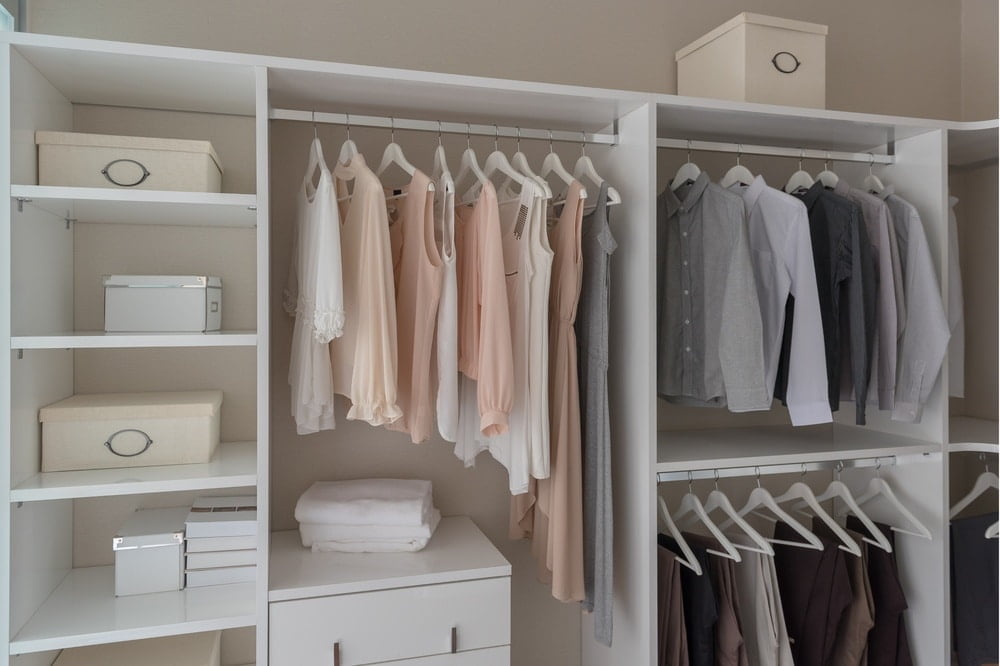 Wall closet that has no doors and has hanging clothes inside