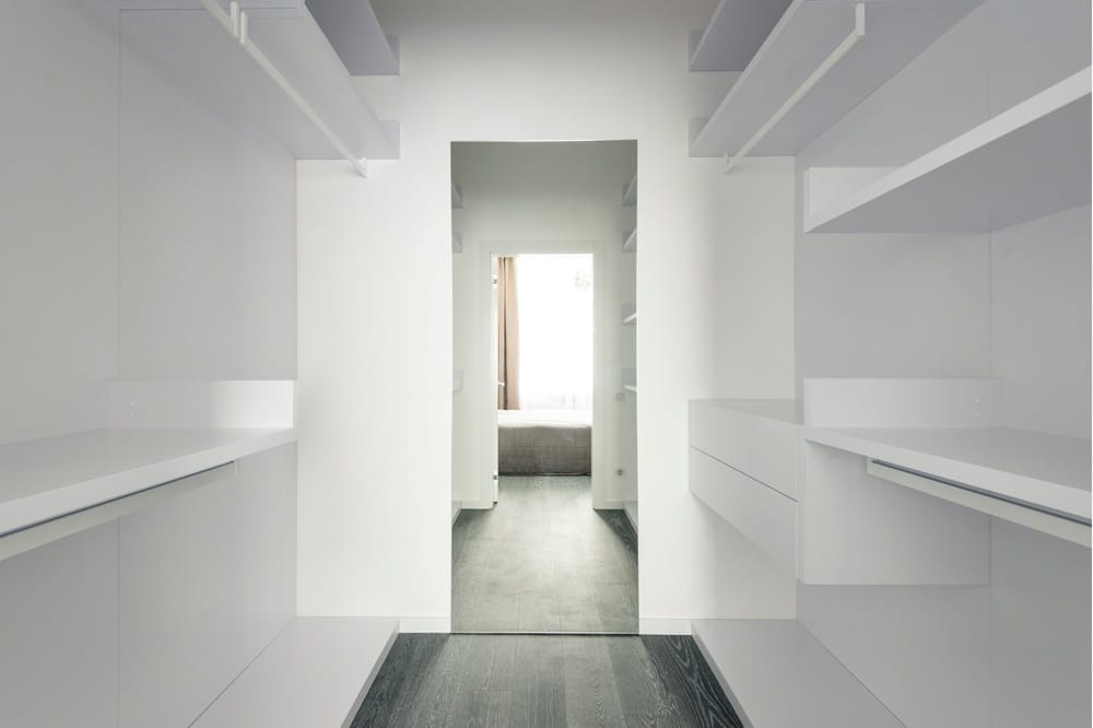 Wall mounted white shelves in narrow closet