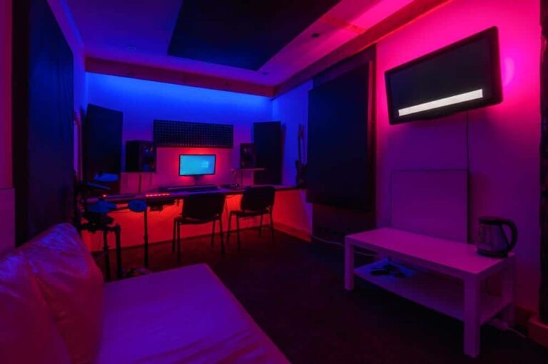 Blue and red lighted room with computer desk and white couch