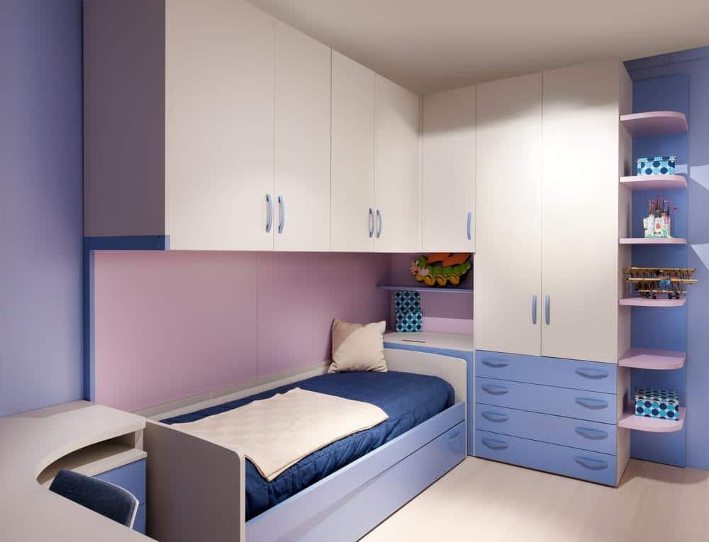 Bedroom with blue and white closets and blue drawers next to a bed