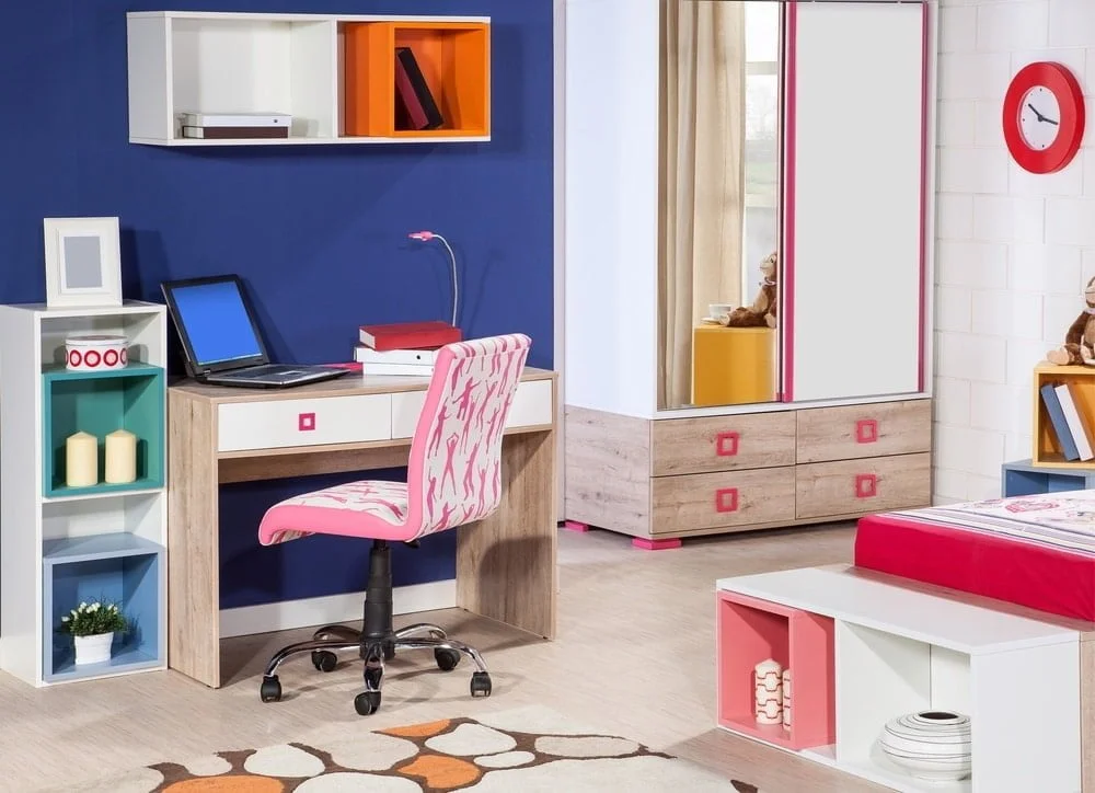 Bright natural lighted children room with multiple drawers, a desk and a pink chair