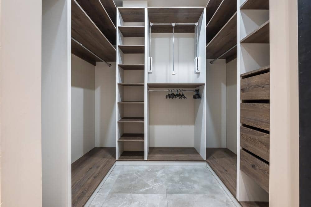 Empty small open shelved walk-in closet with a rug on the floor