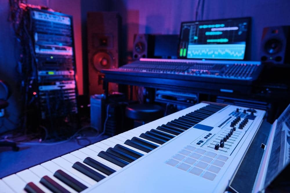 Musical keyboard in a dim lighted room with pc monitor