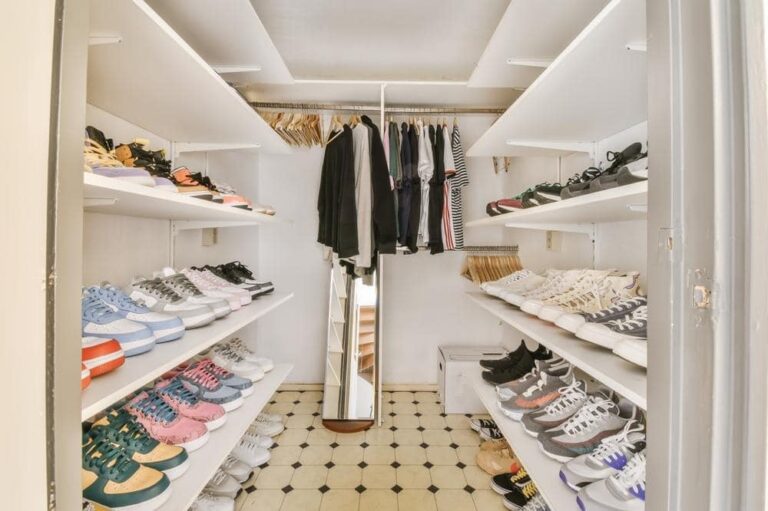 Walk in closet that has open wall mounted shelves full of shoes
