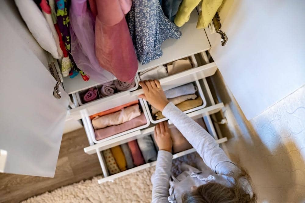 A woman organizing drawers of a full closet