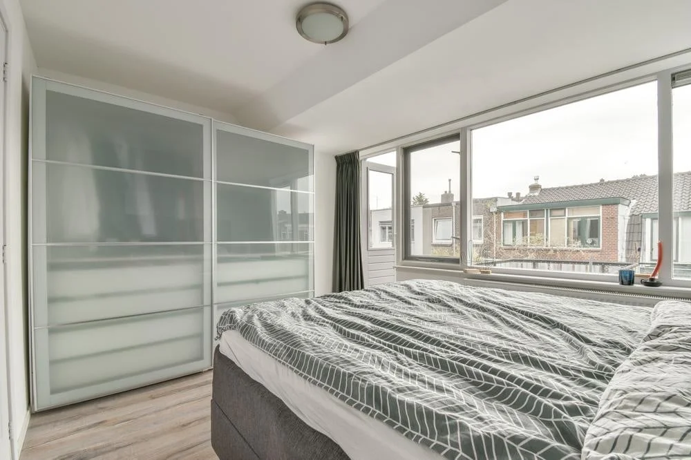 Step into Style: Knock them Dead with These 20 Eye-Catching Closet Door Ideas! 13 Wide windowed bedroom with frosted glass sliding door closet
