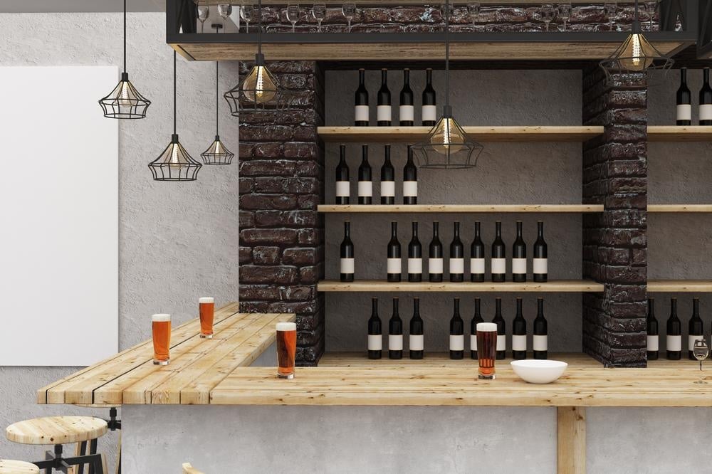 Wooden counter wine bar in a room with wine storage shelves