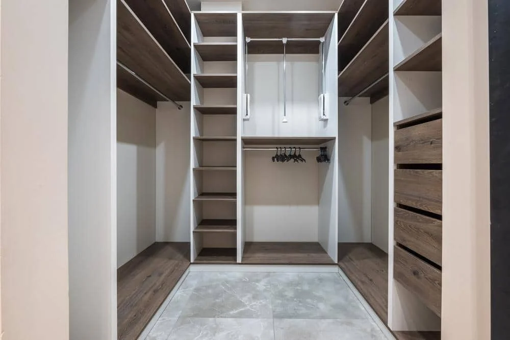 Empty small walk in closet with open shelves and sections