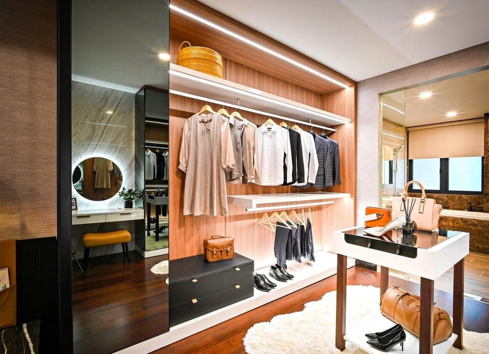 Luxury walk in closet with interior lighting and hangers full of clothes
