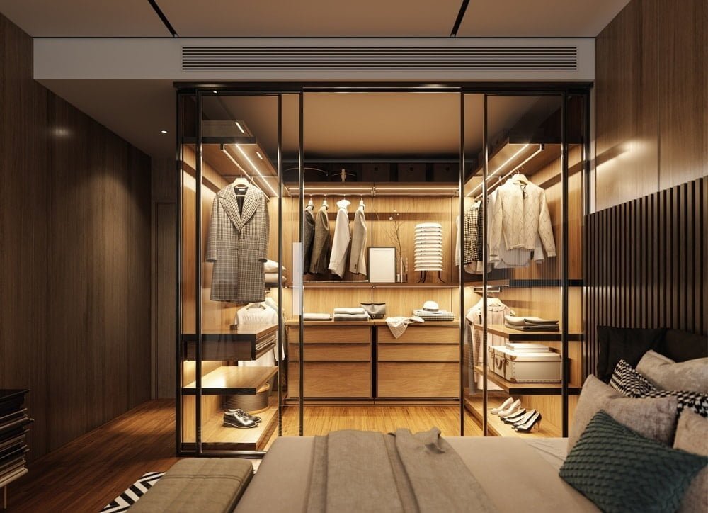 luxury walk in closet with yellow lighting on its shelves