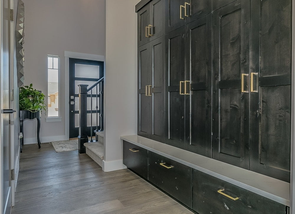 Dark mudroom cabinet and drawers in organized entryway