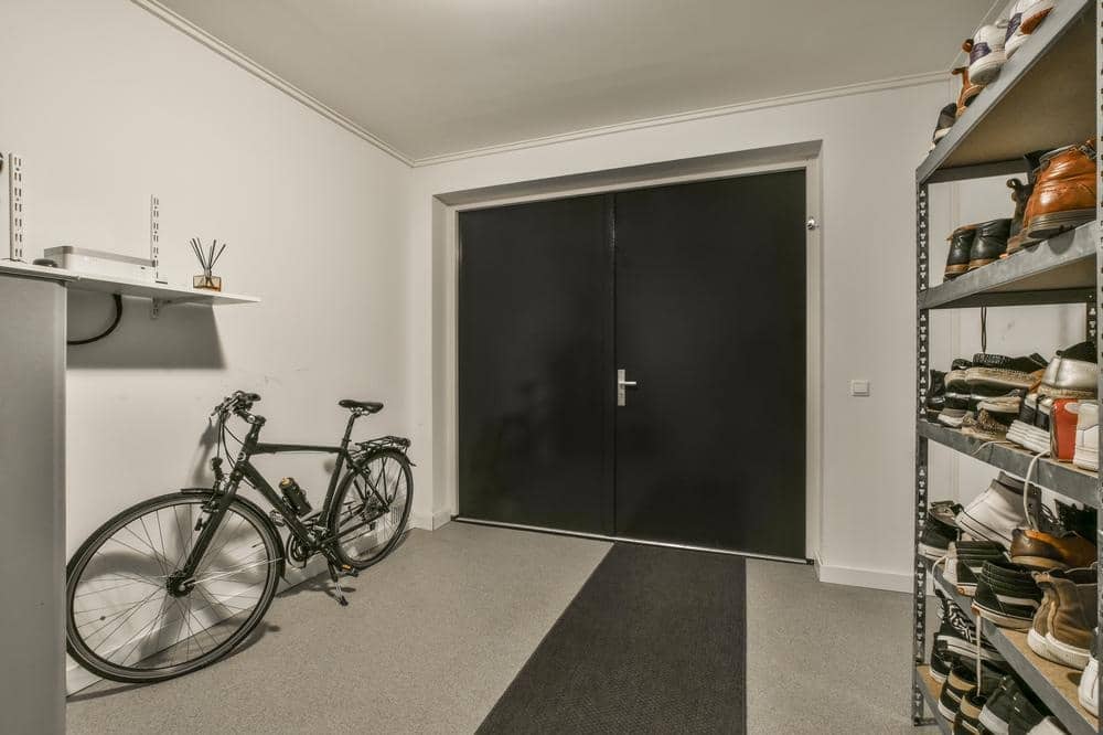 Small garage with standing metal storage shelves and a bike