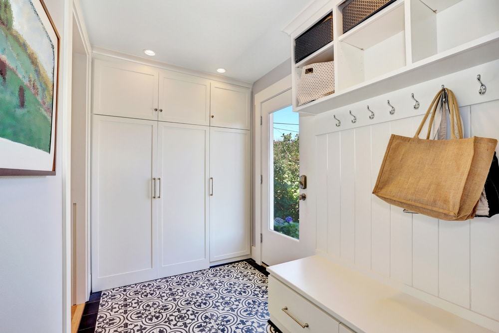 White mudroom with hangers and closets