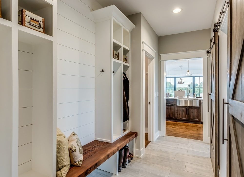 White entryway closet with wooden mudroom bench