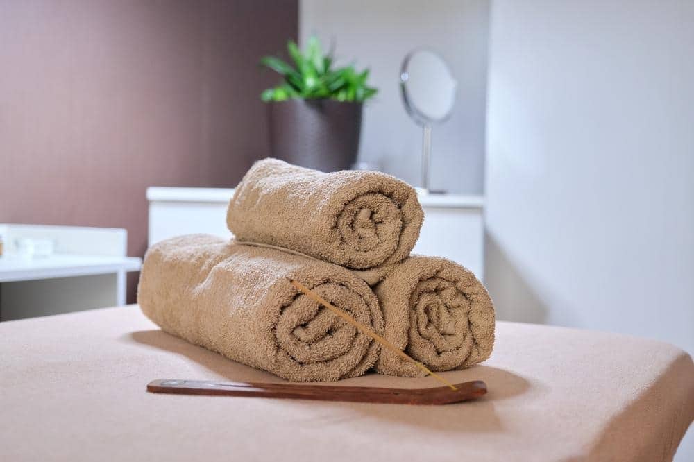 Rolled towels on a pink surface