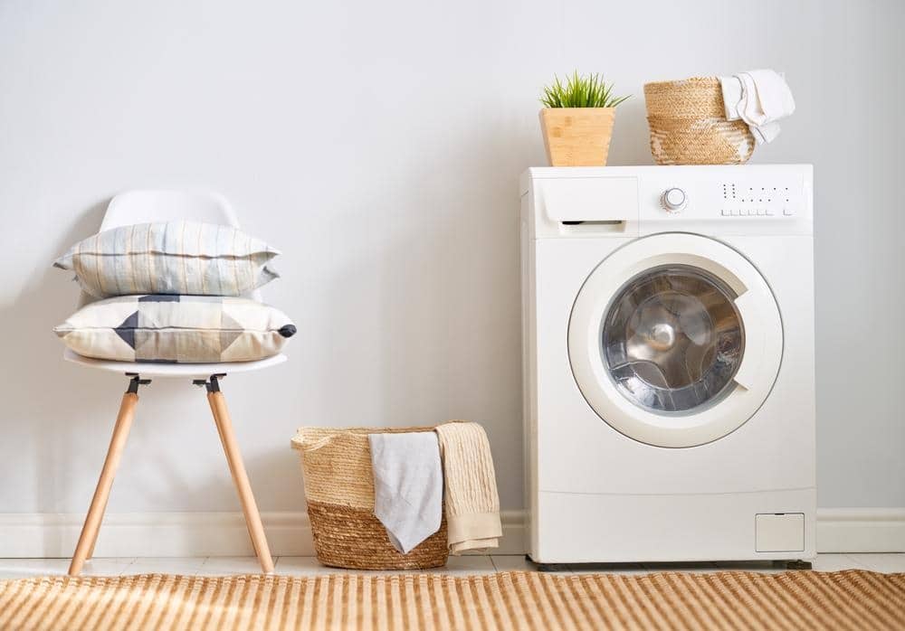 Small laundry rom with a washer and a stool