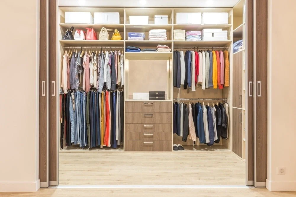 walk in closet with sliding doors and clothes inside