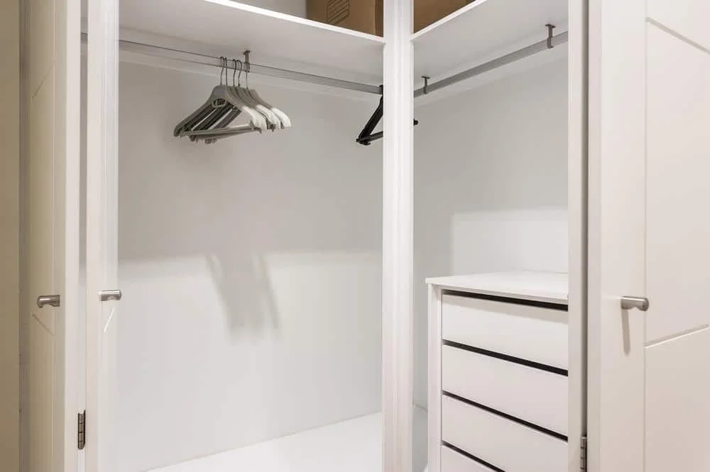 White empty closet with hangers and open door