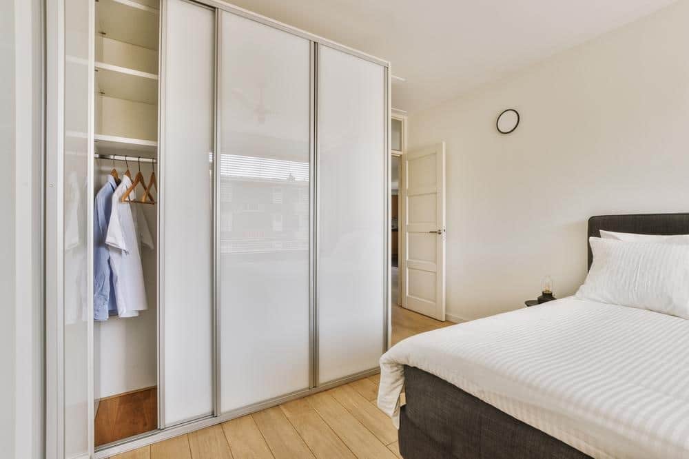 White bedroom sliding door closet in a bedroom with a bed