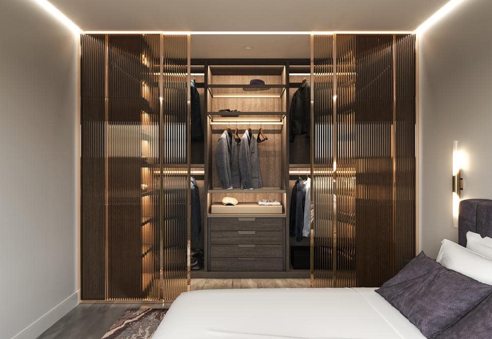 Luxury walk in closet with glass doors and lighted shelves
