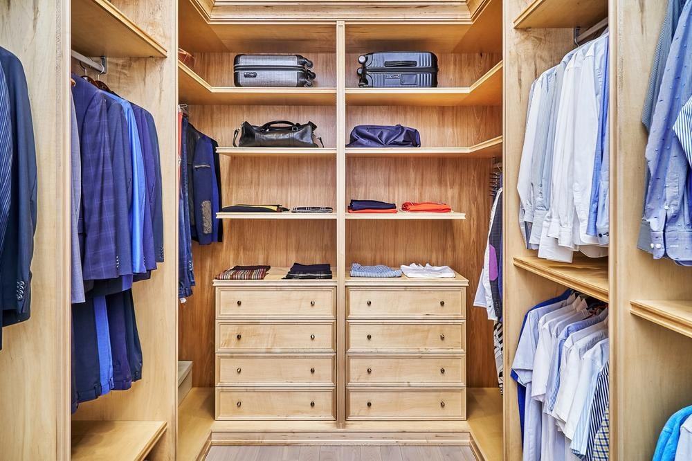Small wooden closet with clothes in it