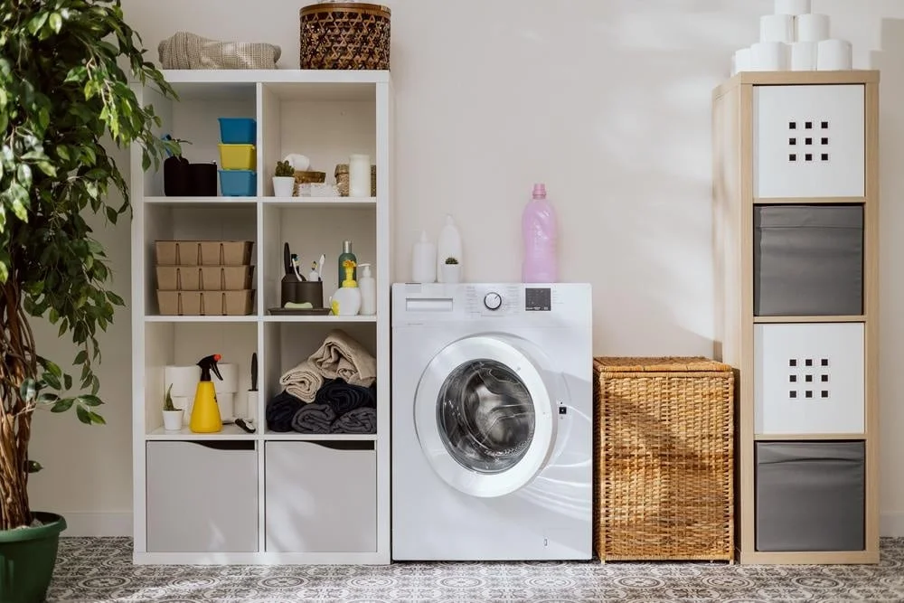 White laundry room with storage baskets and bins with washer